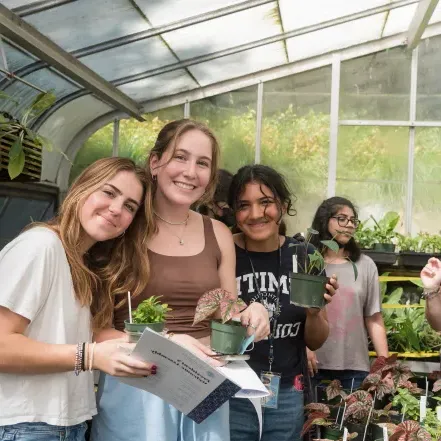一群学生在温室里挑选他们一年级的植物.